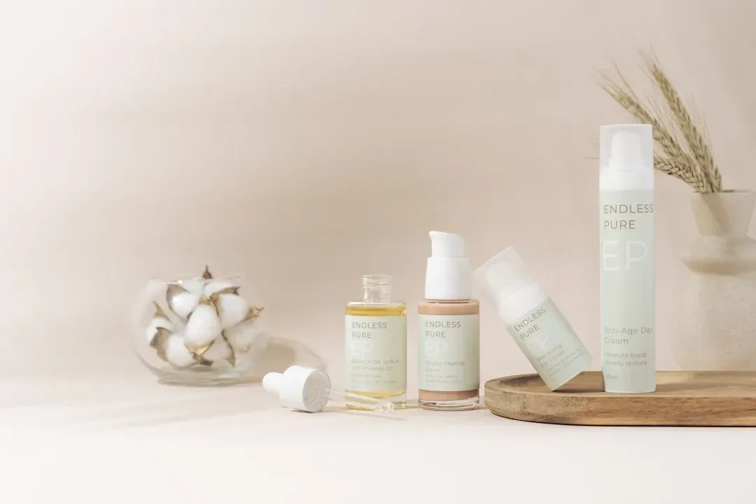 Skincare essentials for looksmaxxing beginners: cleanser, moisturizer, and SPF sunscreen arranged on marble with water drople